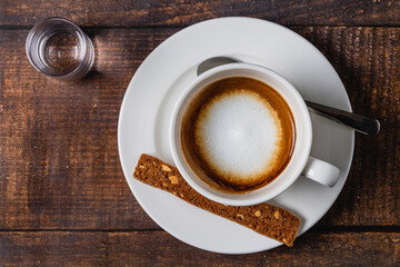 cafe macchiato coffee in white porcelain cup on wooden table