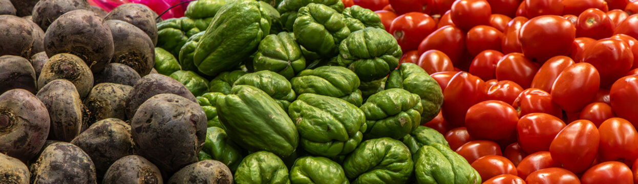 A display of fresh chokos, tomatoes and beetroot at a farmers' market.