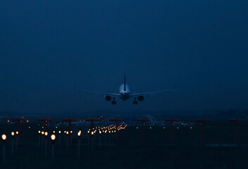 An airplane flies over the runway for landing