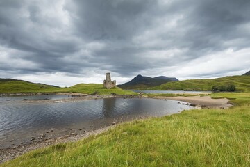 Ruins of Ardvreck Castle on a peninsula in the lake of Loch Assynt, in front of the 764m mountain...