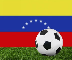 Fototapeta premium The Venezuelan flag and soccer ball on the green grass