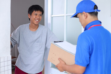 Obraz premium Deliveryman Giving Package To Customer In Front Of The Door 