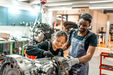 Mechanics working on vehicle engine in auto repair shop