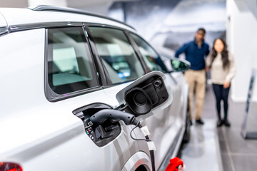 Couple choosing eco friendly vehicle at electric car dealership