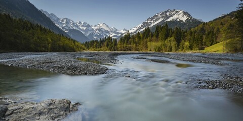 Fototapeta premium Stillach mountain stream in front of snow-covered mountain range, Stillachtal valley near Oberstdorf, Allgäu Alps, Allgäu, Bavaria, Germany, Europe