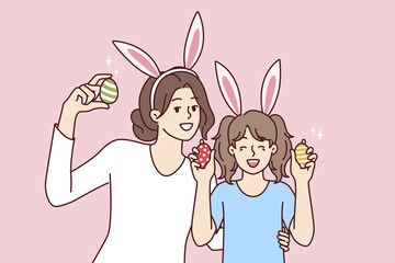 Easter eggs in hands of happy mother and daughter with bunny ears, to celebrate traditional christian holiday. Easter portrait of little girl with nanny or older sister rejoicing in coming of spring