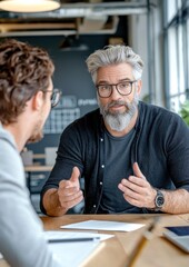 Obraz premium Two professionals engage in a discussion at a modern workspace, highlighting collaboration and mentorship in a business environment.