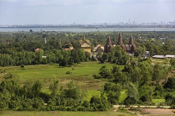 Fototapeta premium Towers of Prasat Phnom Reap temple, rear skyline of Phnom Penh, Cambodia, Asia