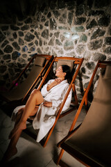 Woman resting peacefully in a salt room wearing a white robe while enjoying relaxation and wellness