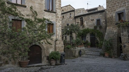 Old tufa buildings decorated with flowers in the hilltop village of Civita di Bagnoregio, Lazio, Italy, Europe
