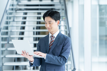 オフィスでパソコンを持つ若いビジネスマン