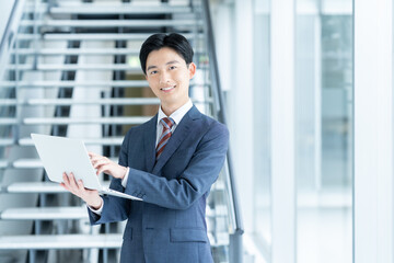 オフィスでパソコンを持つ若いビジネスマン