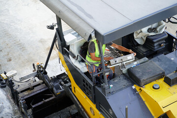 Asphalt paver on a highway construction site, laying a fresh layer of asphalt to create a smooth and durable road surface. Close up.
