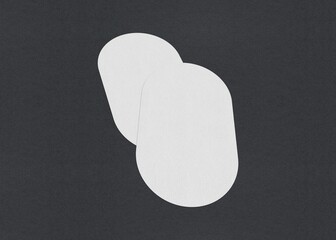 Two white oval sheets overlapping on a dark background, Blank white Business card mockup stacks at grey textured paper background