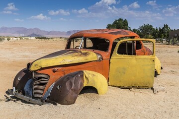 Fototapeta premium Old car wreck in sand, vintage car, Hudson, chassis, Solitaire, Namibia, Africa