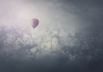 Wonderful adventure, epic scene with a hot air balloon flying over the clouds. Fabulous minimalist view, airship floating in the sky. Travel and journey concept. Inspirational cloudscape scenery