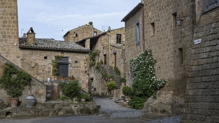 Old tufa buildings decorated with flowers in the hilltop village of Civita di Bagnoregio, Lazio, Italy, Europe