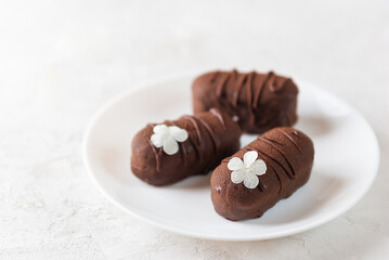Vegan cheesecake candy bar with chocolate glaze, chocolate curd cheese on a plate. Selective focus.