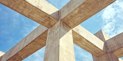 Abstract geometric concrete structure against blue sky with intersecting beams modern architecture design