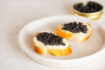 Black caviar appetizers sandwiches in a plate, closeup. Sturgeon caviar.