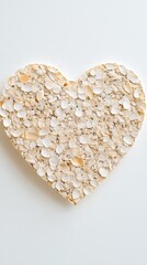 Close-up of a heart-shaped design created with white petals on a minimal, soft-toned background, emphasizing love and purity.