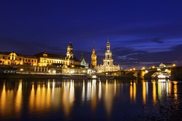Obraz premium Old town at night with Augustus bridge, terrace bank, court church, residence castle and Elbe with water reflection, Dresden, Saxony, Germany, Europe