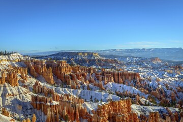 Morning light, snow-covered bizarre rocky landscape with Hoodoos in winter, Sunset Point, Bryce...