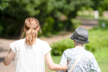 A park with good atmosphere with canal in Toyama Prefecture. Old woman in her 90s and Japanese woman in her thirties are walking around the park.