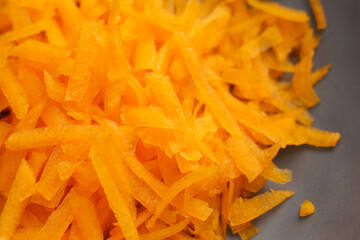 Thin orange strips of grated butternut squash.