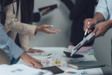 Collaborative Teamwork: A close-up shot focuses on hands actively engaged in reviewing data and documents, showcasing teamwork and collaborative efforts in a modern business setting.