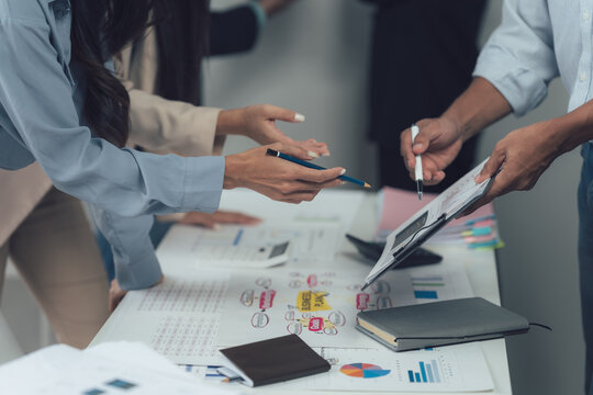 Collaborative Brainstorming: A team of business professionals huddle around a table, actively engaged in a brainstorming session.