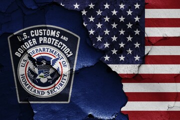 Flags of U.S. Customs and Border Protection and USA painted on cracked wall © daniel0Z/imageBROKER