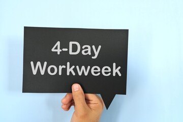 Human hand holding black speech bubble with written 4-day work week.