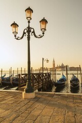 Lamppost with gondolas in San Marco and Benedictine church of San Giorgio Maggiore on San Giorgio...
