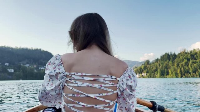 Girl rowing a boat back view beautiful female back beautiful backless dress, femininity, turquoise water lake, feminine and sports