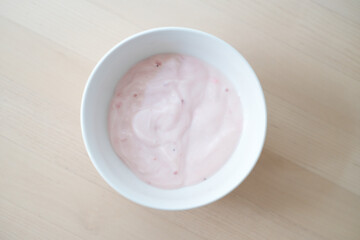 Homemade strawberry yogurt in white bowl.