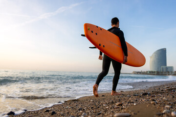Happy young fit man with surfing board at beach, sea and ocean for summer. Travel adventure or hobby
