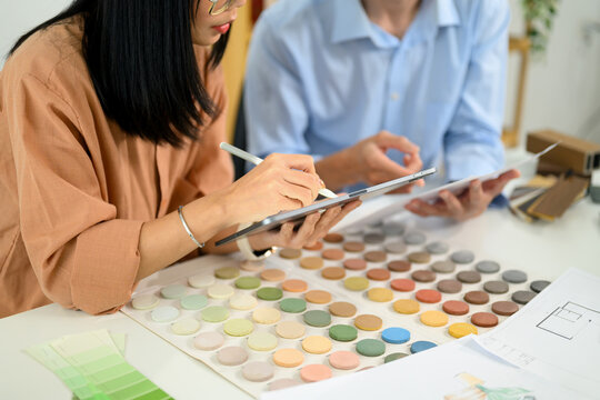 Creative team using digital tablet and reviewing color swatches at co working space