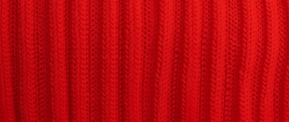 Fototapeta premium Close-up of vibrant red fabric with vertical ribbed texture, showcasing intricate woven details.