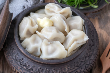 Siberian dumplings boiled with butter. Dumplings in traditional clay dishes