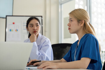 Diverse female healthcare professionals engaged in a focused discussion during a team meeting.