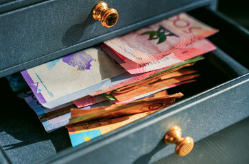 Tenge banknotes of different denominations are lying in a casket