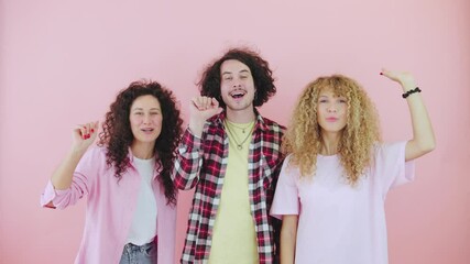 Three curly-haired friends waving goodbye and saying bye on a bright pink background with three cheerful people expressing their happiness and carefree spirit