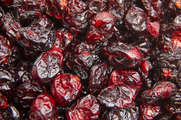 Macro shot of dried cranberries showcasing their vibrant red color, wrinkled texture, and glossy surface. Ideal for food or nutrition-related content