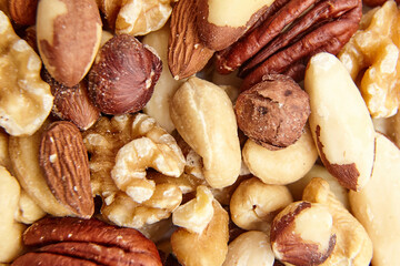 Close-up of assorted mixed nuts, including walnuts, hazelnuts, pecans, Brazil nuts, cashews, and almonds, highlighting natural textures and variety