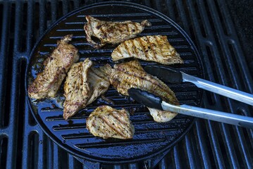 Grilled turkey meat, turkey steaks on the grill, with barbecue tong, Bavaria, Germany, Europe