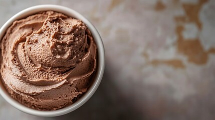 Chocolate ice cream in a white cup on marble.