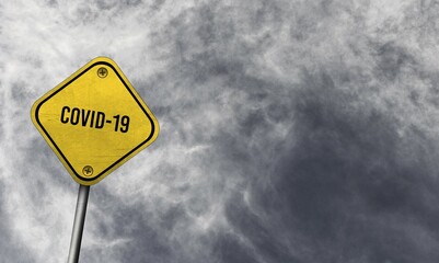 Yellow covid-19 sign with cloudy background