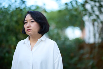 Portrait of smiling middle aged Asian business women in natural background