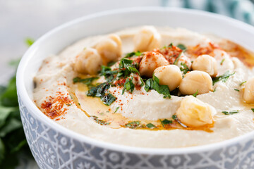 Chickpea hummus with olive oil, parsley and paprika on black background. Close up